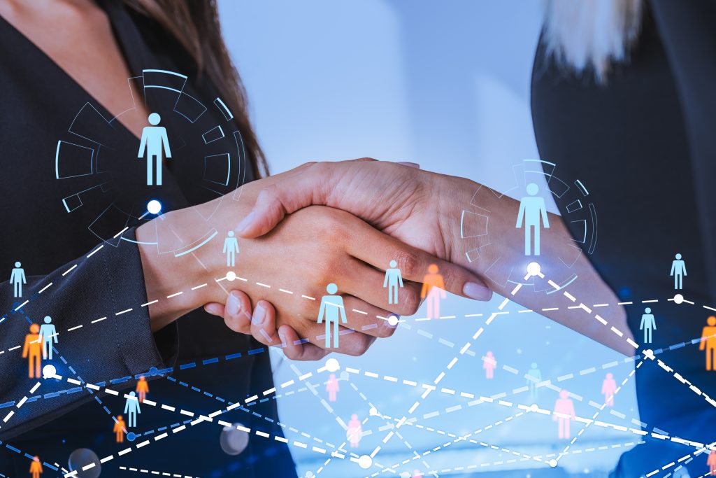 Two businesswomen shaking hands, glowing hologram of people network and connection, double exposure, recruitment and communication. Concept of signing a contract