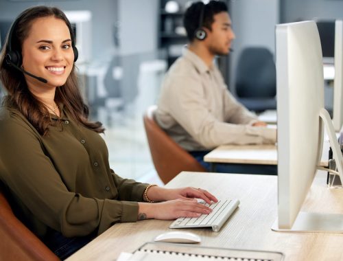 Woman typing at computer, call center and contact us with communication and CRM with tech support. Customer service, help desk and telemarketing, female consultant and smile in portrait with telecom.